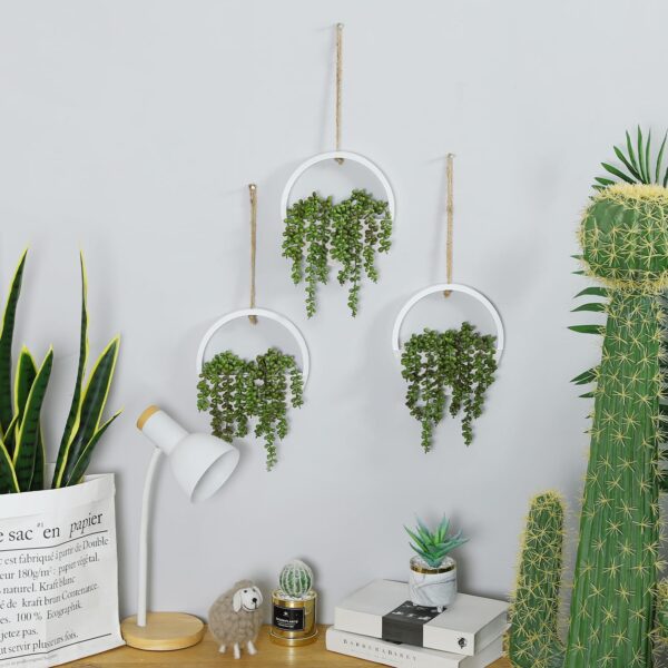 Artificial hanging plants on the wall in three pieces, creating an aesthetic indoor decor.