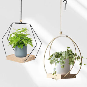 Hexagonal black plant hanger with plants inside, used in an indoor setting.