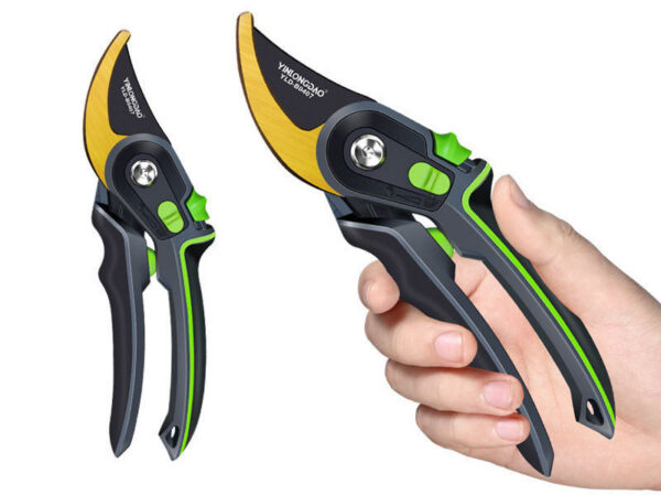 Gold pruning shears held in hand for trimming small branches.