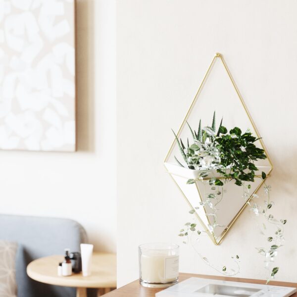 One large White and Brass wall planter with plant in a cozy interior