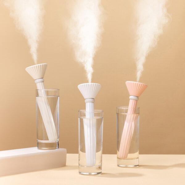 Portable humidifier for plants in 3 colors, placed on a desk in an indoor setting with a potted plant.